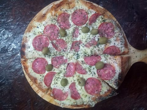 Pizza con calabresa sobre una pala